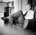 831205 Portret van W.J. van der Linden (1908-1980), zittend met gesloten ogen in een fauteuil in de woonkamer van zijn ...